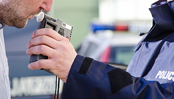 A police officer conducts an alcohol breath test